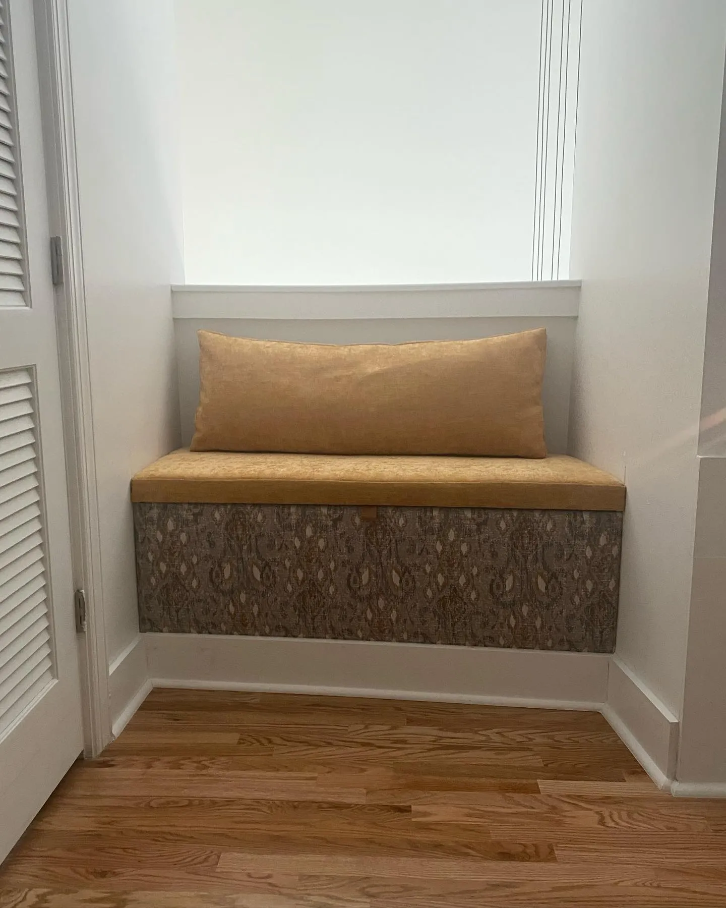 Built-in window seat with an upholstered cushion and panelled base