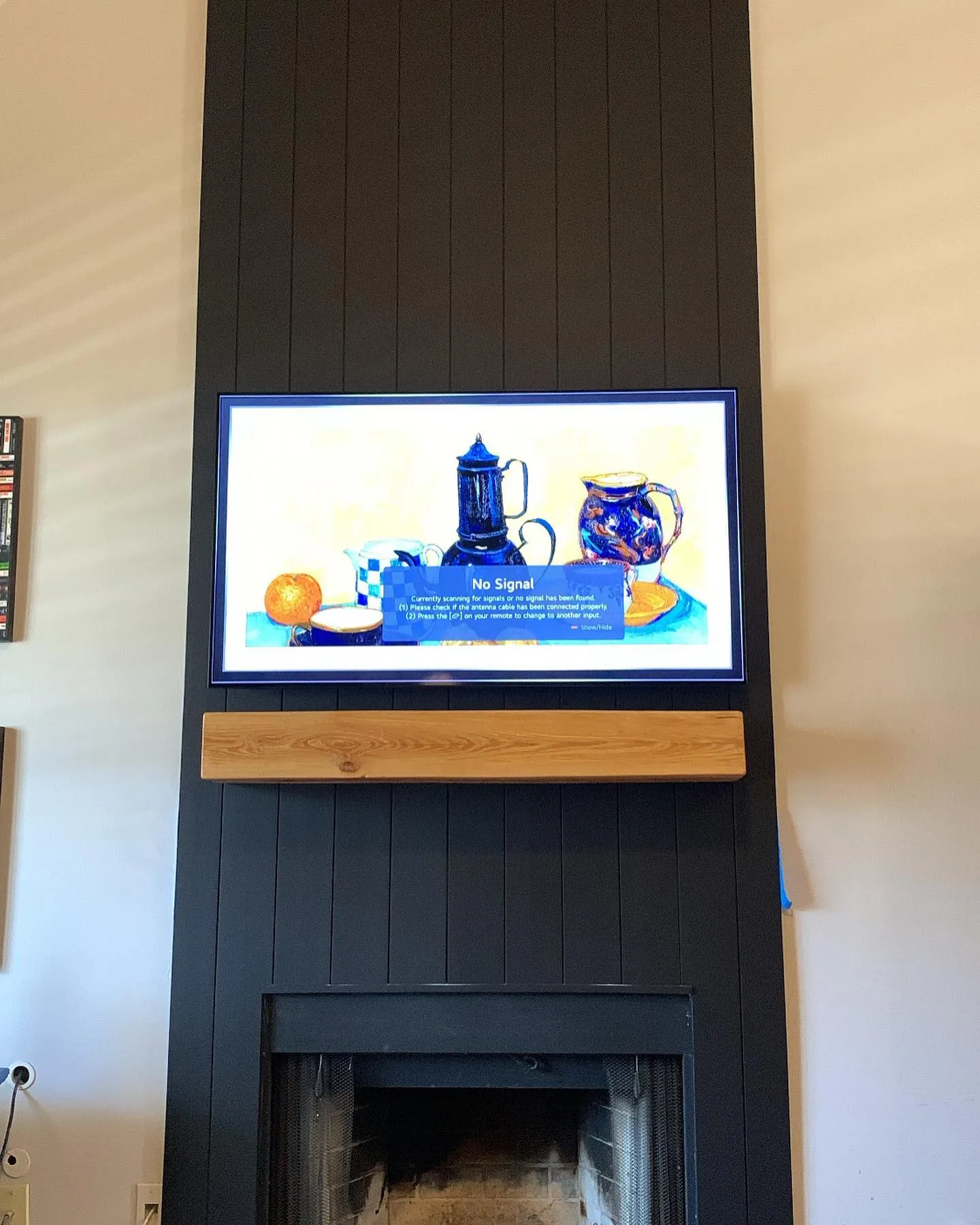 Black vertical shiplap fireplace wall with a floating timber mantel