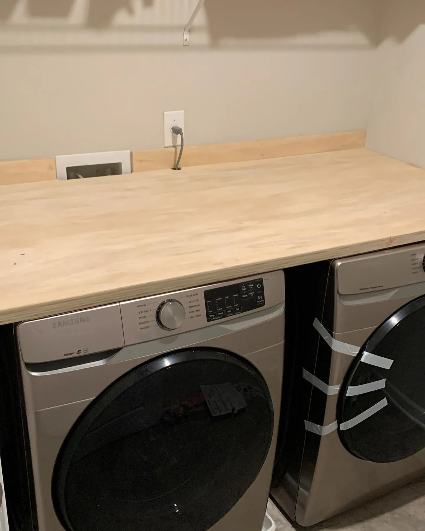 Timber counter built over a washer and dryer in a laundry room