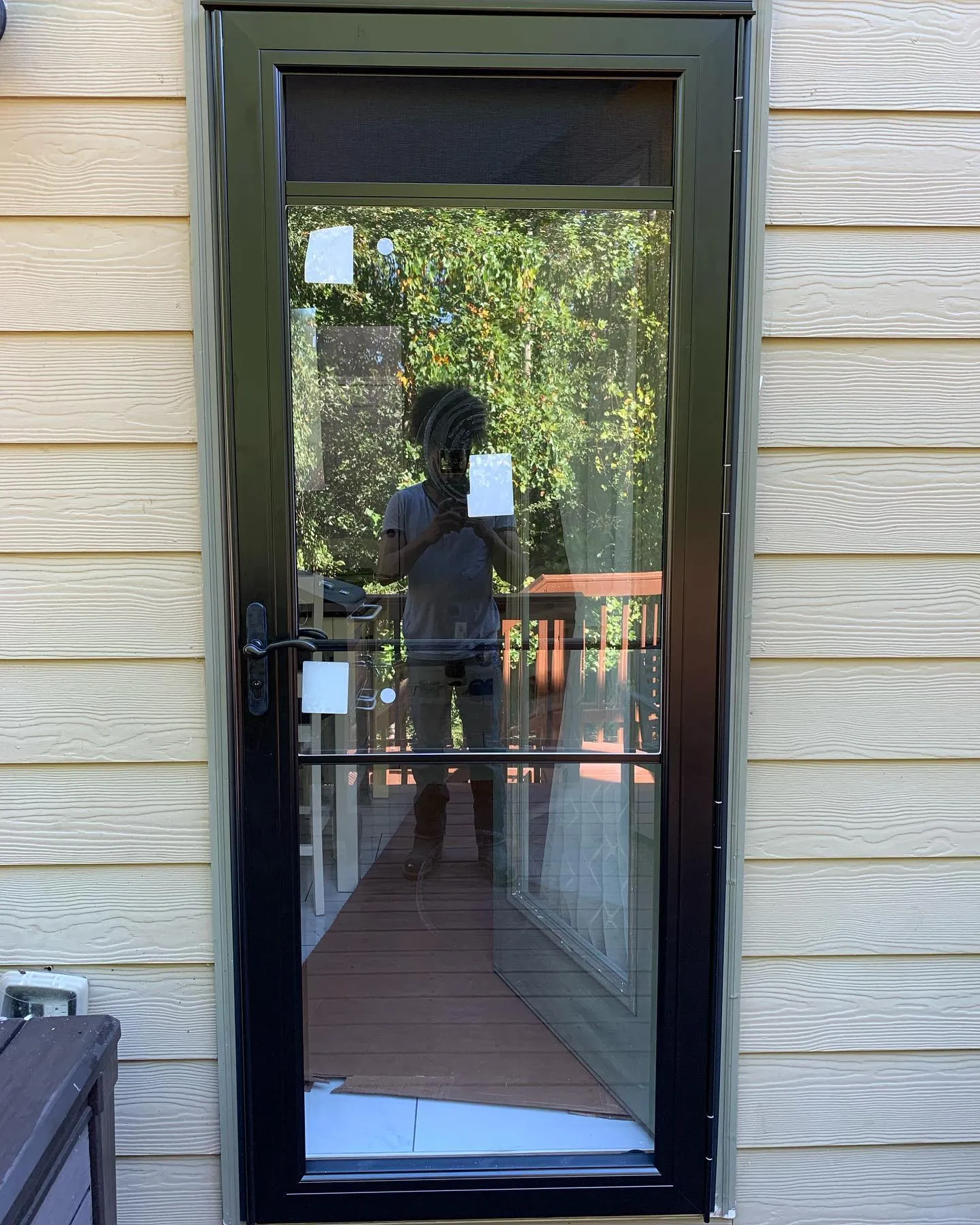 Black framed storm door fitted to a rear entrance