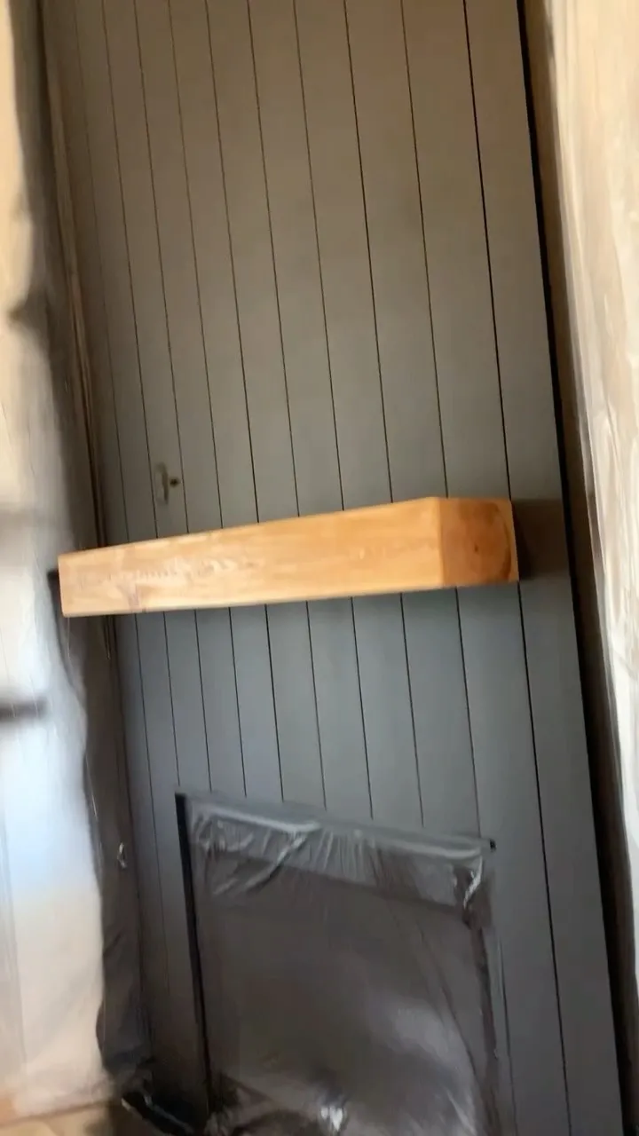 Dark panelled feature wall with a solid timber mantel shelf